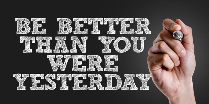 Hand holding sharpie with the following message “Be better than you were yesterday”