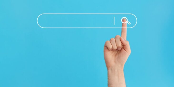 Turquoise background with a white search functio,n with a finger poised over the magnification icon to execute the search